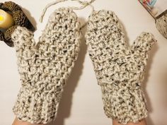 a pair of knitted mittens with an owl on top and a candle in the middle