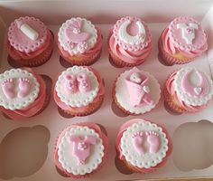 cupcakes with pink and white frosting in a box