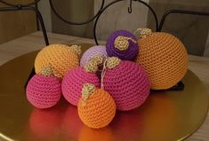 small crocheted pumpkins sitting on top of a golden plate with gold trim