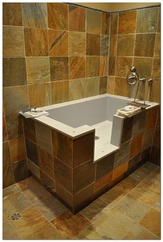 a bath tub sitting in the middle of a tiled bathroom