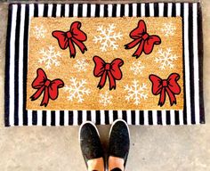 a person standing in front of a door mat with bows on it