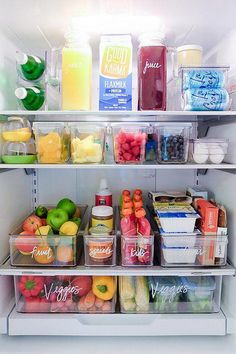 an open refrigerator filled with lots of different types of fruits and vegetables in plastic containers