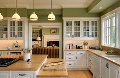 a kitchen with green walls and white cabinets