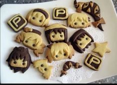 some cookies are on a white plate with brown and yellow icing, along with other decorated cookies