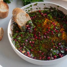 a white bowl filled with food next to bread