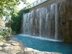 a large waterfall in the middle of a pool