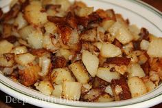 a white bowl filled with cooked potatoes on top of a wooden table