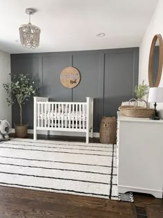 a baby's room with gray walls and white furniture