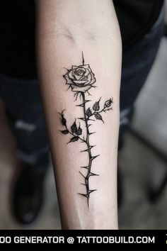 a black and white photo of a rose tattoo on the arm