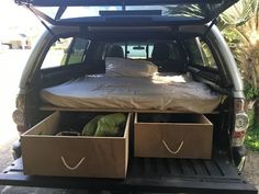 the bed in the back of a truck with two drawers on it's side