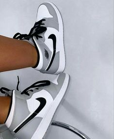 a woman's legs with black and white nike shoes