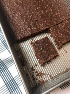 chocolate squares sitting on top of a metal pan next to a blue and white checkered table cloth