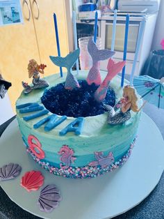 a birthday cake with mermaid decorations on top