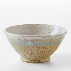 a brown and blue bowl sitting on top of a white table