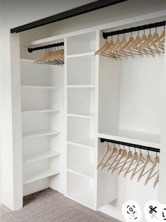 an empty closet with white shelves and wooden clothes hangers on the wall next to it