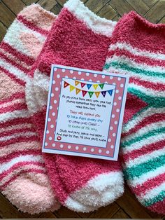 two pairs of pink and green striped socks with a card attached to the top one