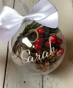 a glass ornament filled with pine cones and berries