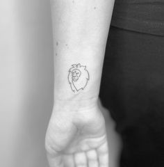 a woman's wrist with a small lion tattoo on the left side of her arm