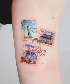 three postage stamps on the left side of a woman's arm