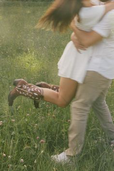 a man and woman are kissing in the grass