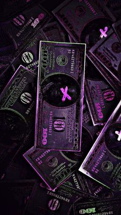 a pile of twenty dollar bills sitting on top of each other in purple light,