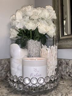 there is a candle and some flowers in the holder on the sink counter next to the mirror