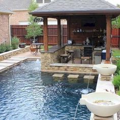 an outdoor kitchen and pool area in a backyard