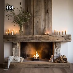 a fireplace with candles and logs in front of it