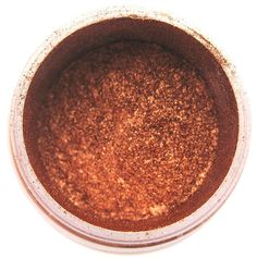 a cup filled with brown powder on top of a white table