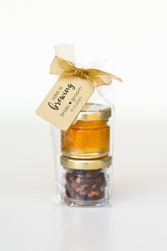 three small jars filled with different types of teas and spices, tied with a gold ribbon