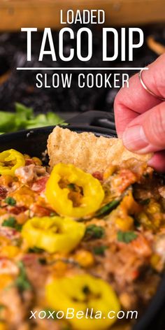 someone dipping some food into a skillet with the text loaded taco dip slow cooker