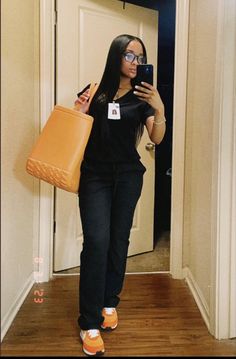 a woman is taking a selfie with her cell phone while holding a brown bag