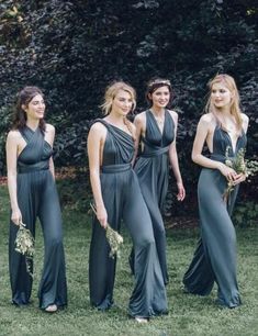 four beautiful women in long dresses standing next to each other