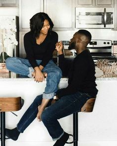 a man and woman sitting at a kitchen counter