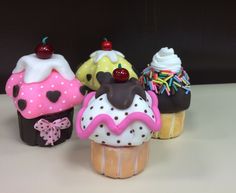 there are four cupcakes with different toppings on top of each cake cone