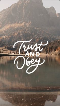 the words trust and obey written in white over a lake with mountains in the background