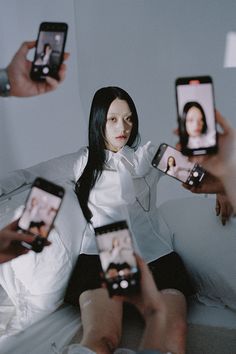 four people holding up their cell phones to take pictures with the same person on them