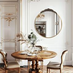 a dining room table with chairs and a round mirror