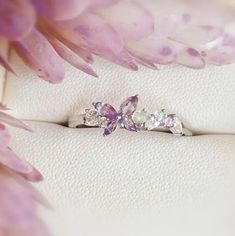 a close up of a ring with flowers in the background