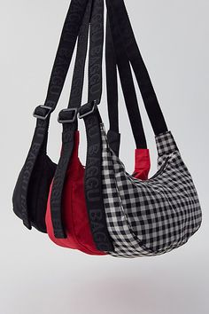 three purses hanging from the ceiling with black and white checkered fabric on them