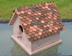 a bird house made out of coins on top of a table