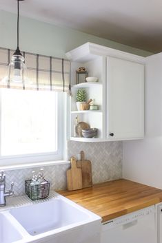 a kitchen with white cabinets and wooden counter tops