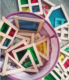 a bowl filled with lots of different colored wooden toys