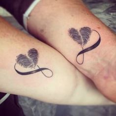 two people with matching tattoos on their feet, one is holding the other's hand