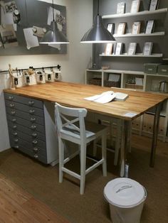 a desk with several drawers and two chairs