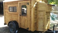 a small wooden trailer with windows on the side