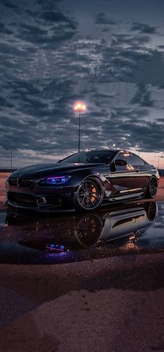 a black car parked in front of a parking lot at night