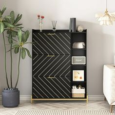 a living room with a black cabinet next to a potted plant