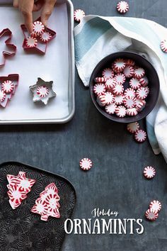 red and white candies are on a tray next to a cookie sheet with the words holiday ornaments