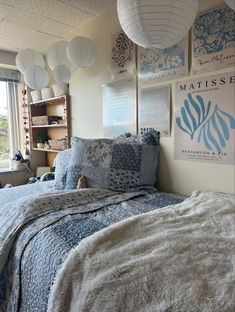 a bed room with a neatly made bed and lots of pictures on the wall above it